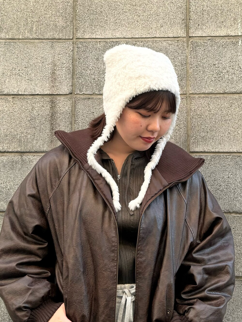 ホワイト系のニットキャップ/ビーニーを着用したレディースの冬コーディネートの2枚目の写真