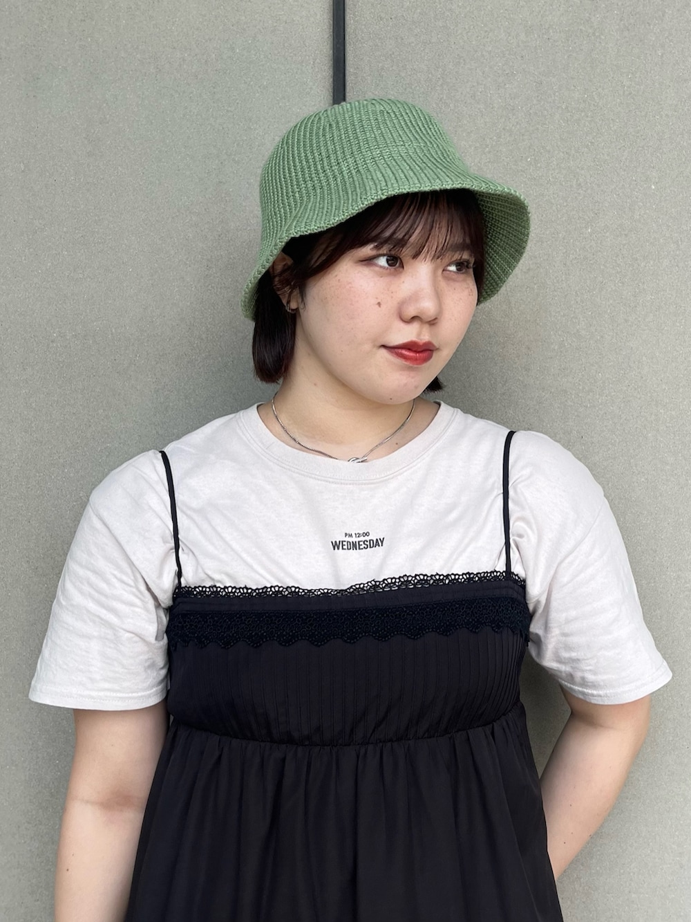ブラック系のワンピース、グリーン系のハットを着用したレディースの夏コーディネートの3枚目の写真