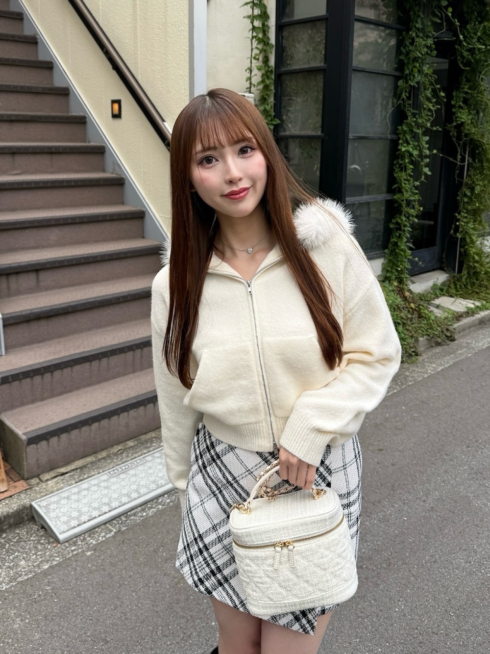 ホワイト系のスカート、ホワイト系のパーカー、ブラック系のブーツを着用したレディースの秋コーディネートの2枚目の写真