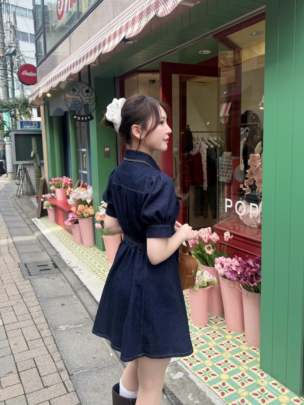 ブルー系のワンピース、ブラウン系のボストンバッグ、ブラウン系のブーツを着用したレディースの春コーディネートの3枚目の写真