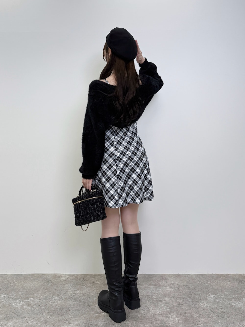 ブラック系のショルダーバッグ、ブラック系のワンピース、ブラック系のブーツを着用したレディースの秋コーディネートの4枚目の写真