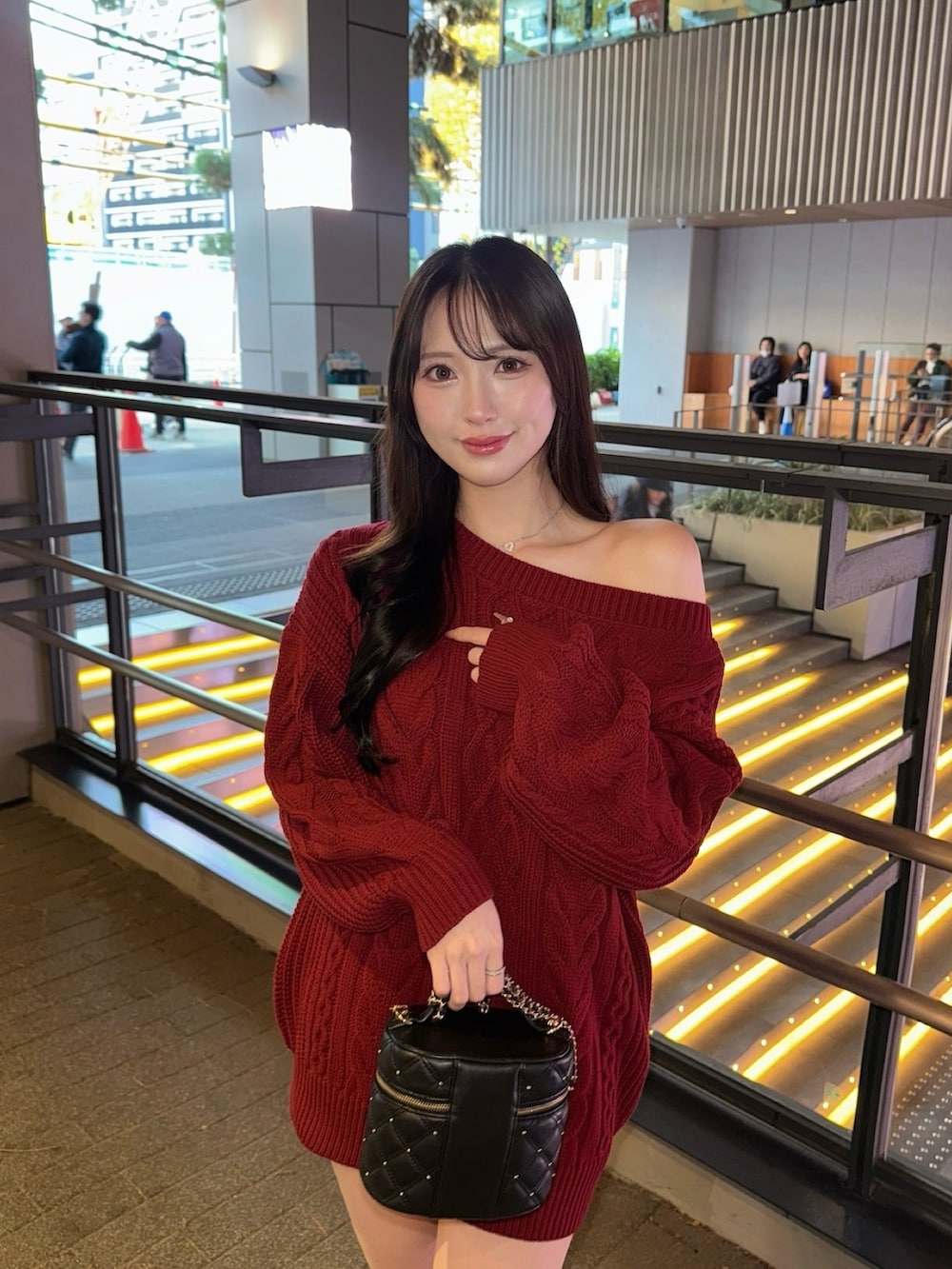 レッド系のニット/セーター、ブラック系のその他パンツ、ブラック系のブーツを着用したレディースの秋コーディネートの3枚目の写真