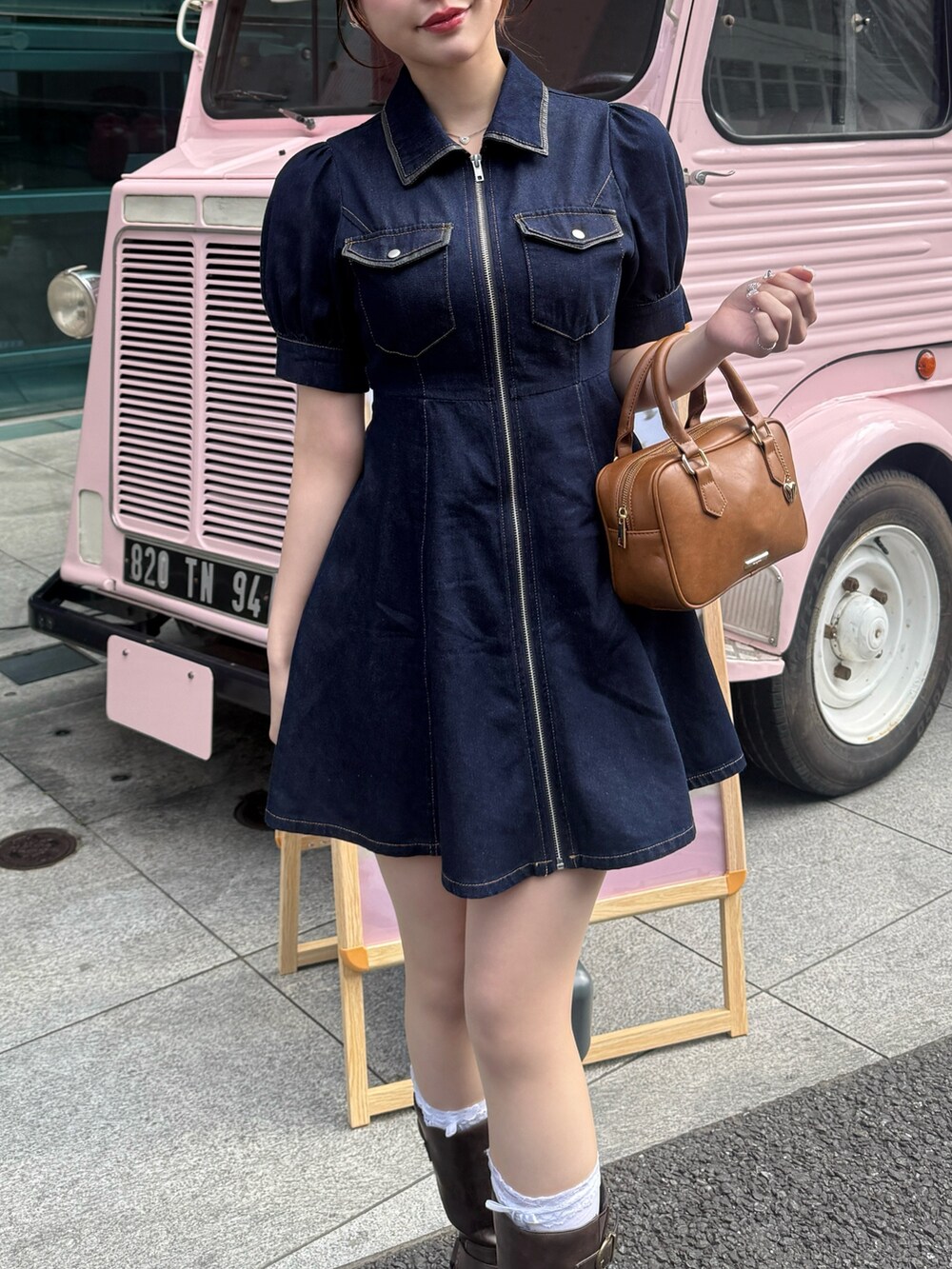 ブルー系のワンピース、ブラウン系のボストンバッグ、ブラウン系のブーツを着用したレディースの春コーディネートの5枚目の写真