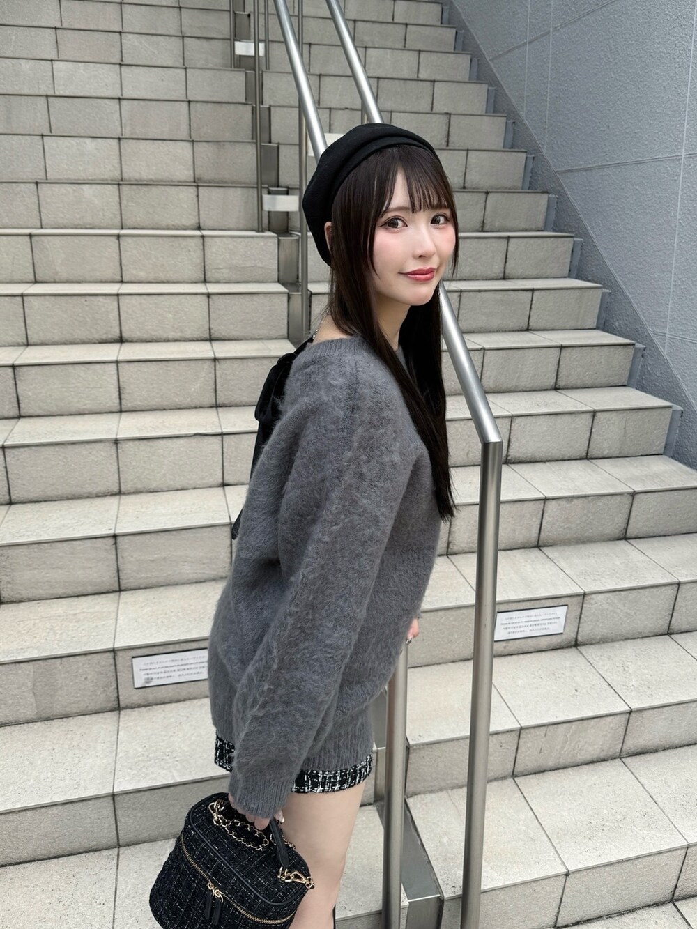 グレー系のニット/セーター、ブラック系のショルダーバッグ、ブラック系のブーツを着用したレディースの秋コーディネートの3枚目の写真