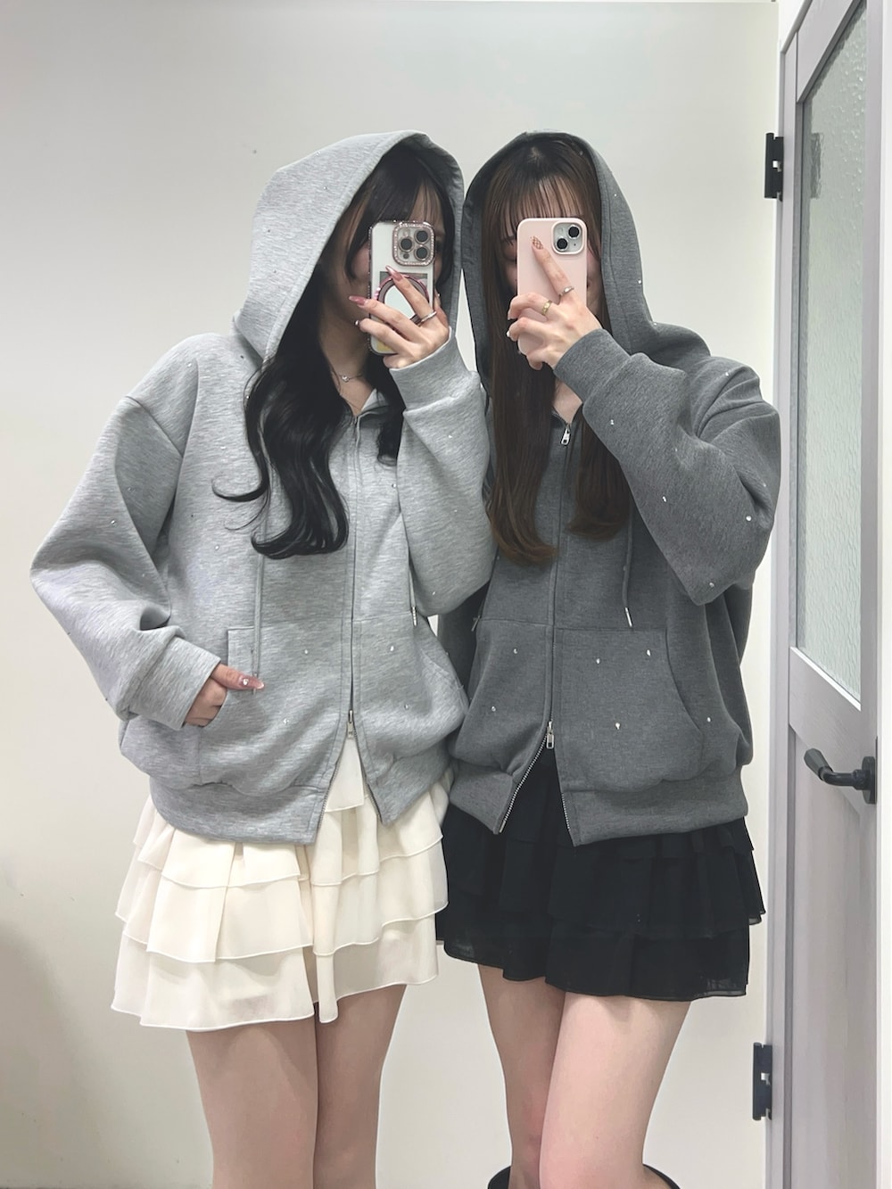 グレー系のパーカー、ホワイト系のスカート、ブラック系のブーツを着用したレディースの冬コーディネートの3枚目の写真