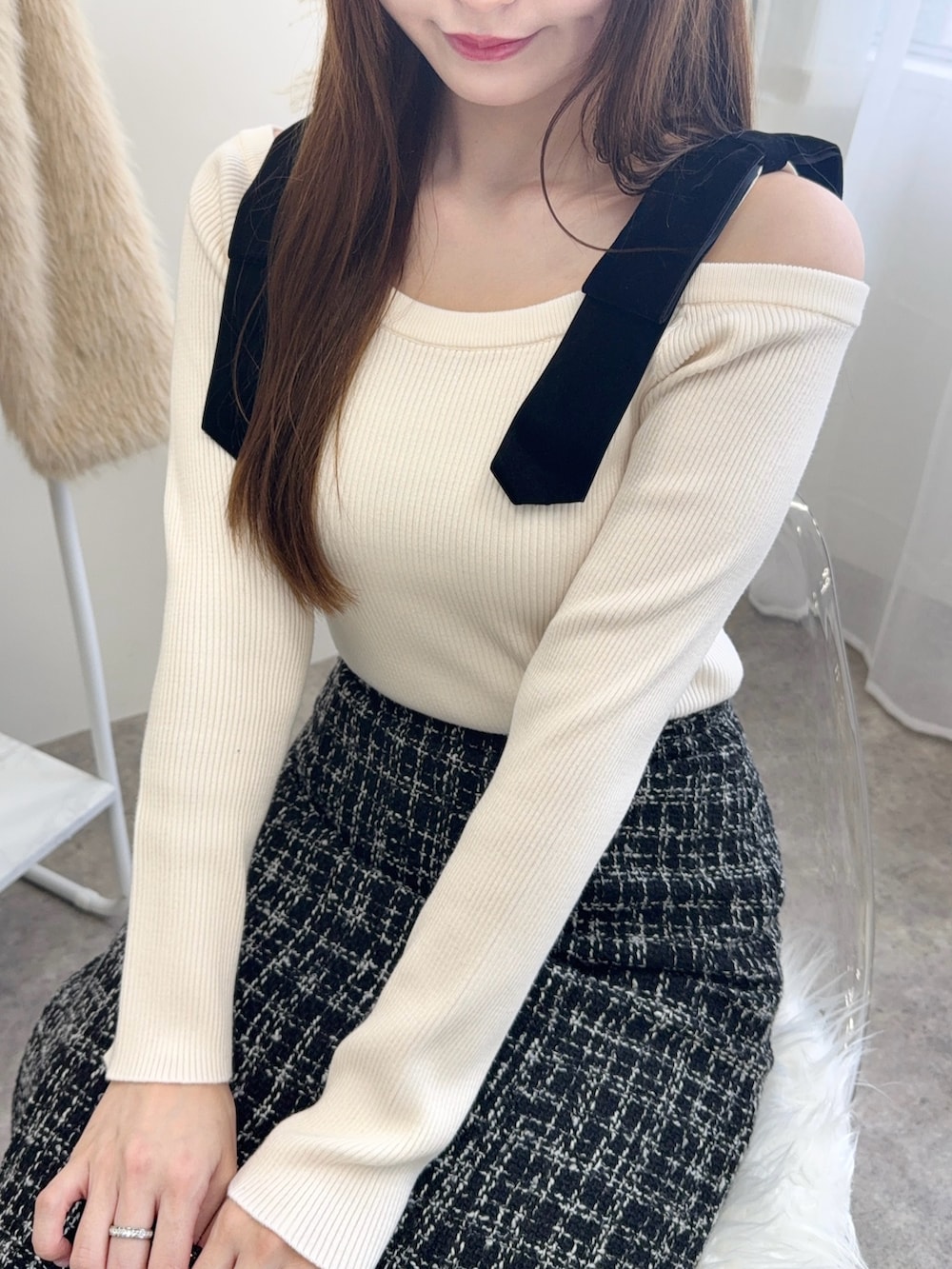 ブラック系のショルダーバッグ、ホワイト系のニット/セーター、ブラック系のスカートを着用したレディースの秋コーディネートの3枚目の写真