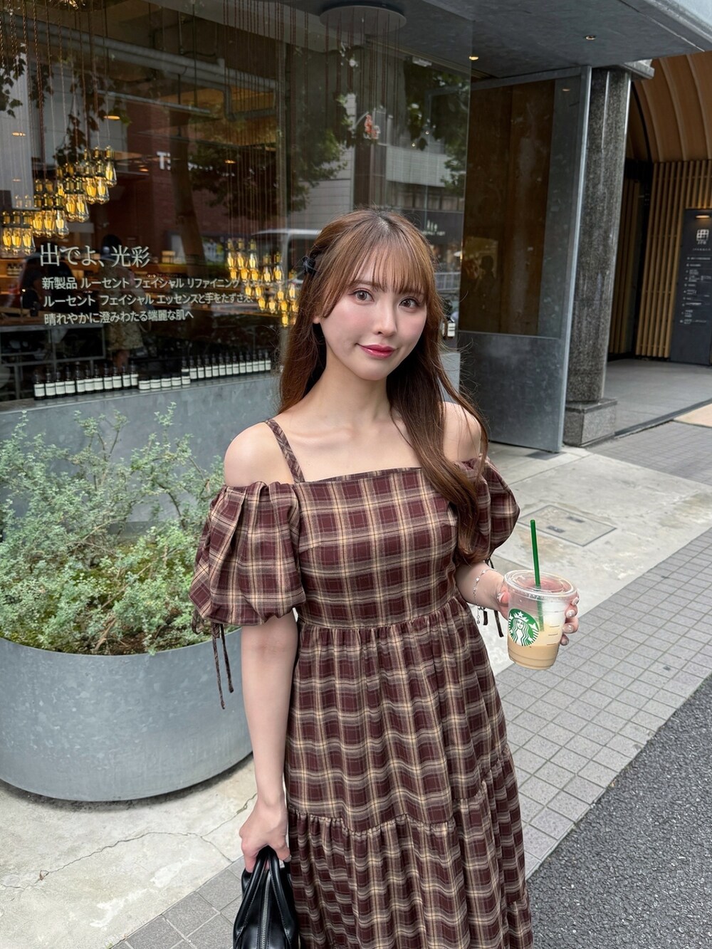 レッド系のワンピース、ブラック系のハンドバッグ、ブラック系のサンダルを着用したレディースの夏コーディネートの3枚目の写真