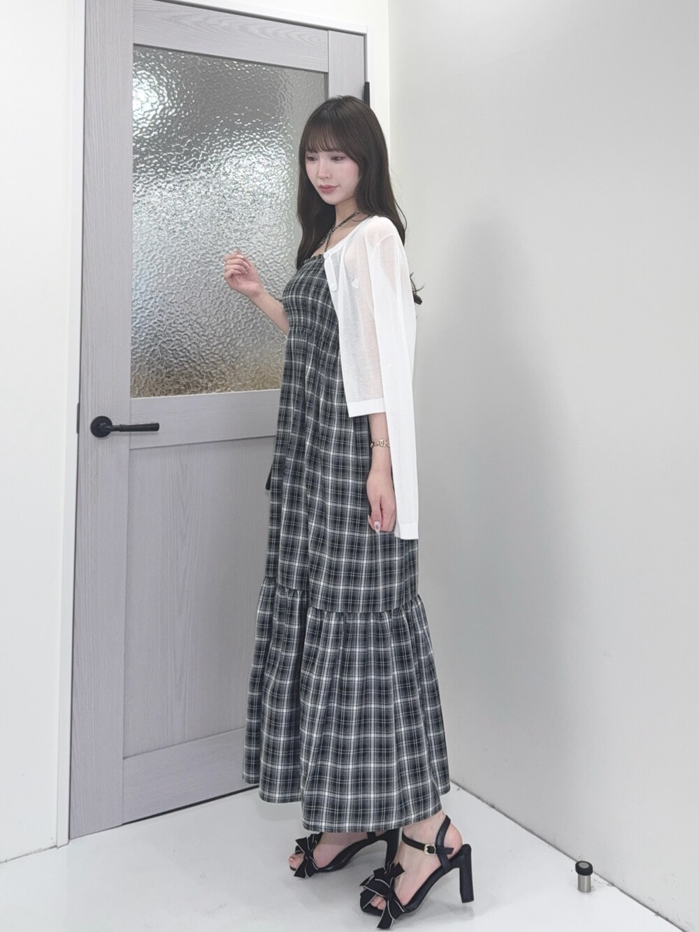 ホワイト系のカーディガン/ボレロ、ブラック系のワンピース、ブラック系のショルダーバッグを着用したレディースの夏コーディネートの2枚目の写真