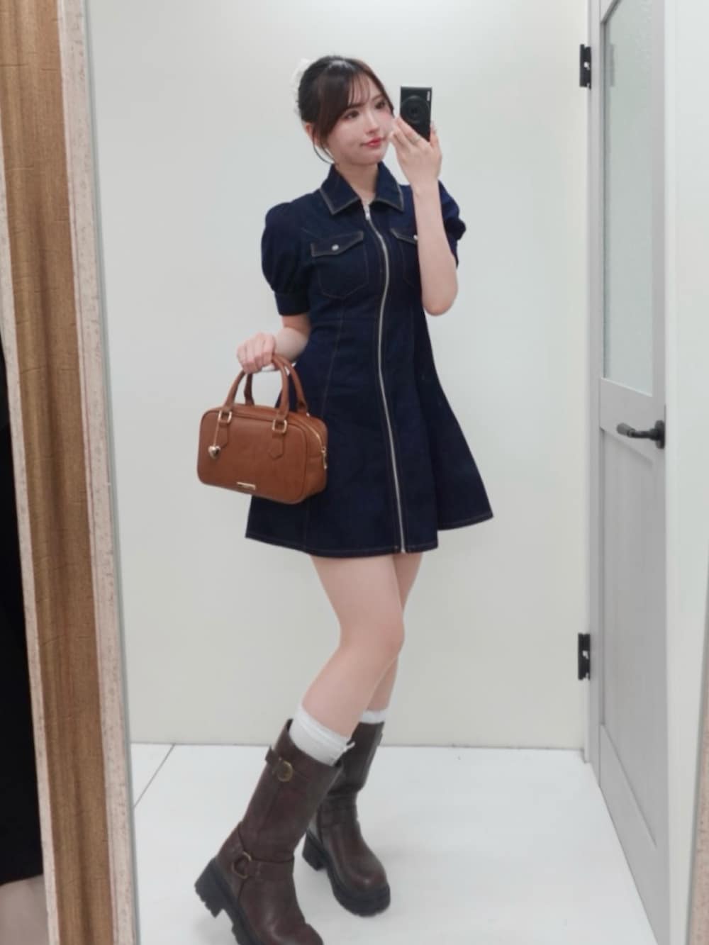 ブルー系のワンピース、ブラウン系のボストンバッグ、ブラウン系のブーツを着用したレディースの春コーディネートの4枚目の写真