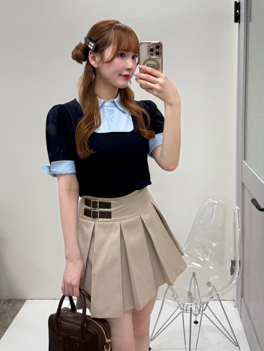 ベージュ系のスカート、ブラック系のパンプス、ブラウン系のボストンバッグを着用したレディースの春コーディネートの3枚目の写真