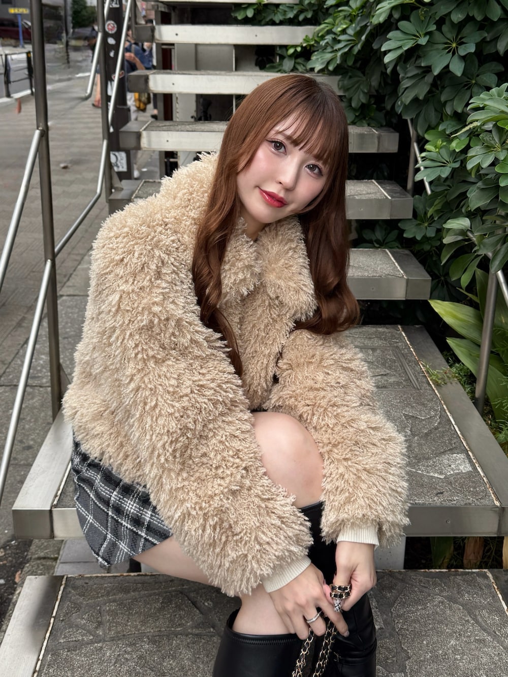 ベージュ系のブルゾン、ブラック系のショルダーバッグ、グレー系のスカートを着用したレディースの秋コーディネートの3枚目の写真