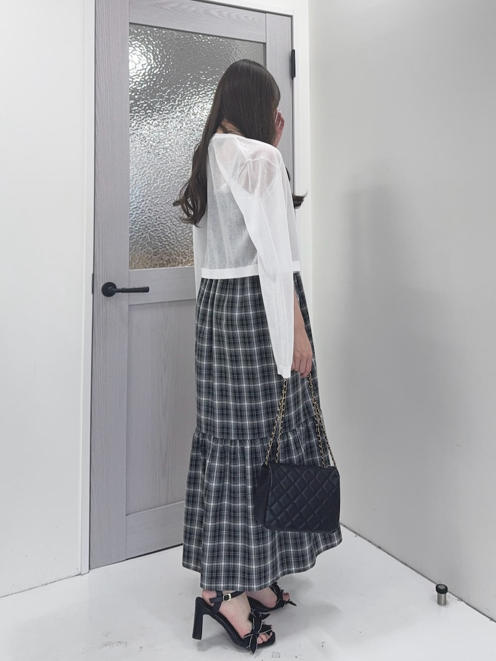 ホワイト系のカーディガン/ボレロ、ブラック系のワンピース、ブラック系のショルダーバッグを着用したレディースの夏コーディネートの3枚目の写真