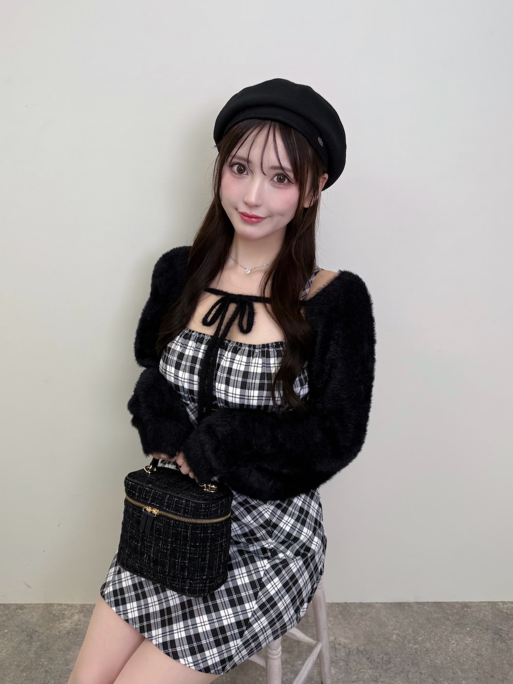 ブラック系のショルダーバッグ、ブラック系のワンピース、ブラック系のブーツを着用したレディースの秋コーディネートの5枚目の写真