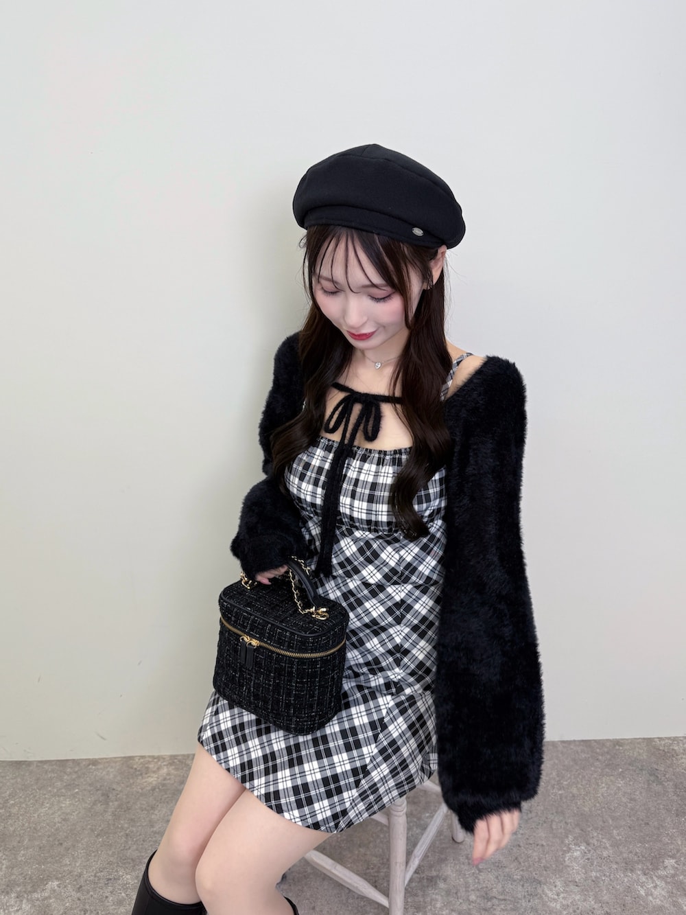 ブラック系のショルダーバッグ、ブラック系のワンピース、ブラック系のブーツを着用したレディースの秋コーディネートの3枚目の写真