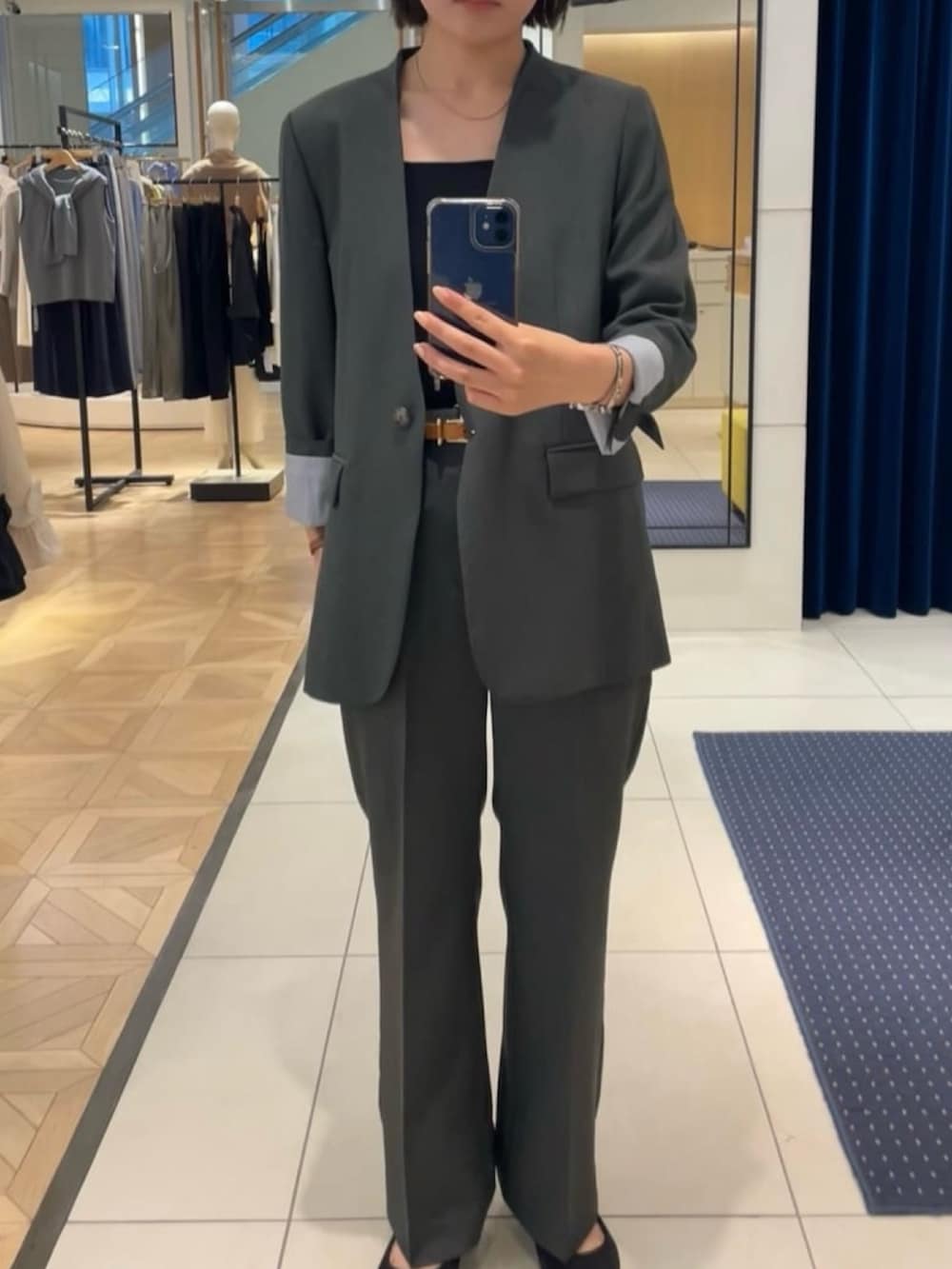 グレー系のノーカラージャケット、グレー系のその他パンツ、ブラック系のタンクトップを着用したレディースの秋コーディネートの2枚目の写真
