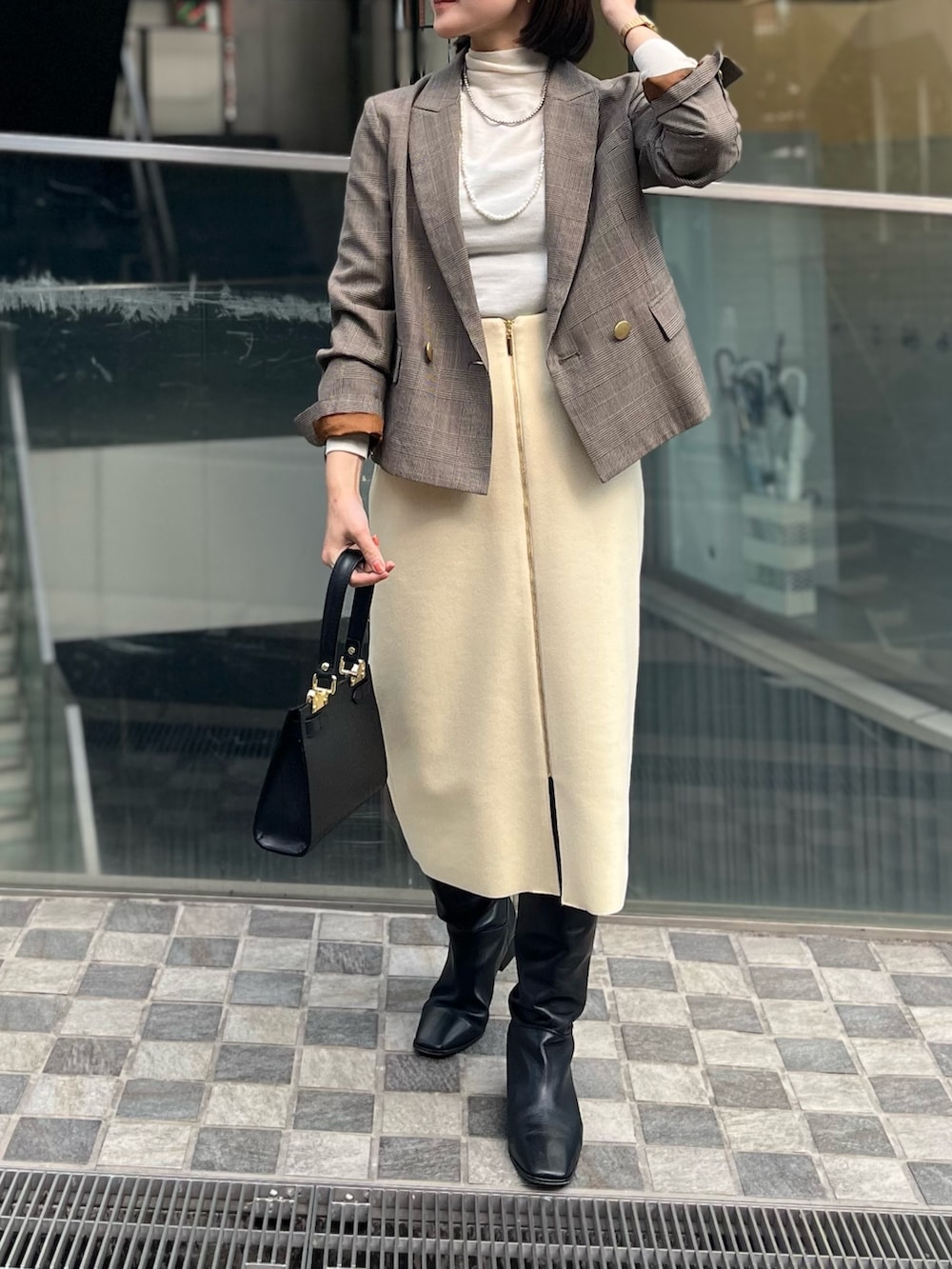 ベージュ系のテーラードジャケット、ホワイト系のニット/セーター、イエロー系のスカートを着用したレディースの冬コーディネートの3枚目の写真