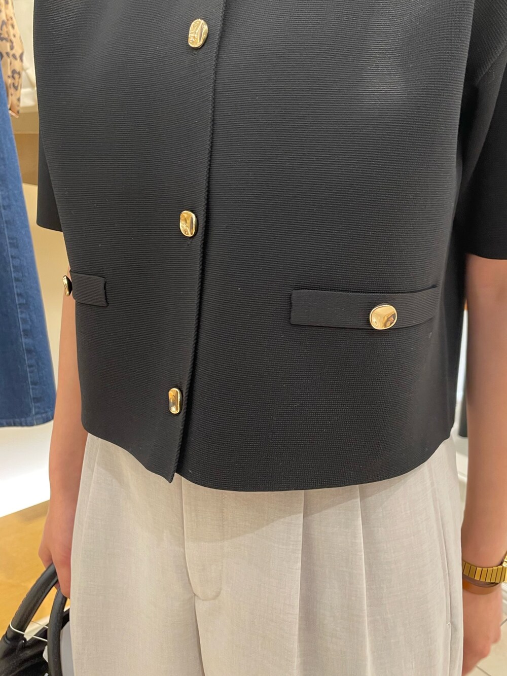 ブラック系のノーカラージャケット、グレー系のその他パンツを着用したレディースの春コーディネートの6枚目の写真