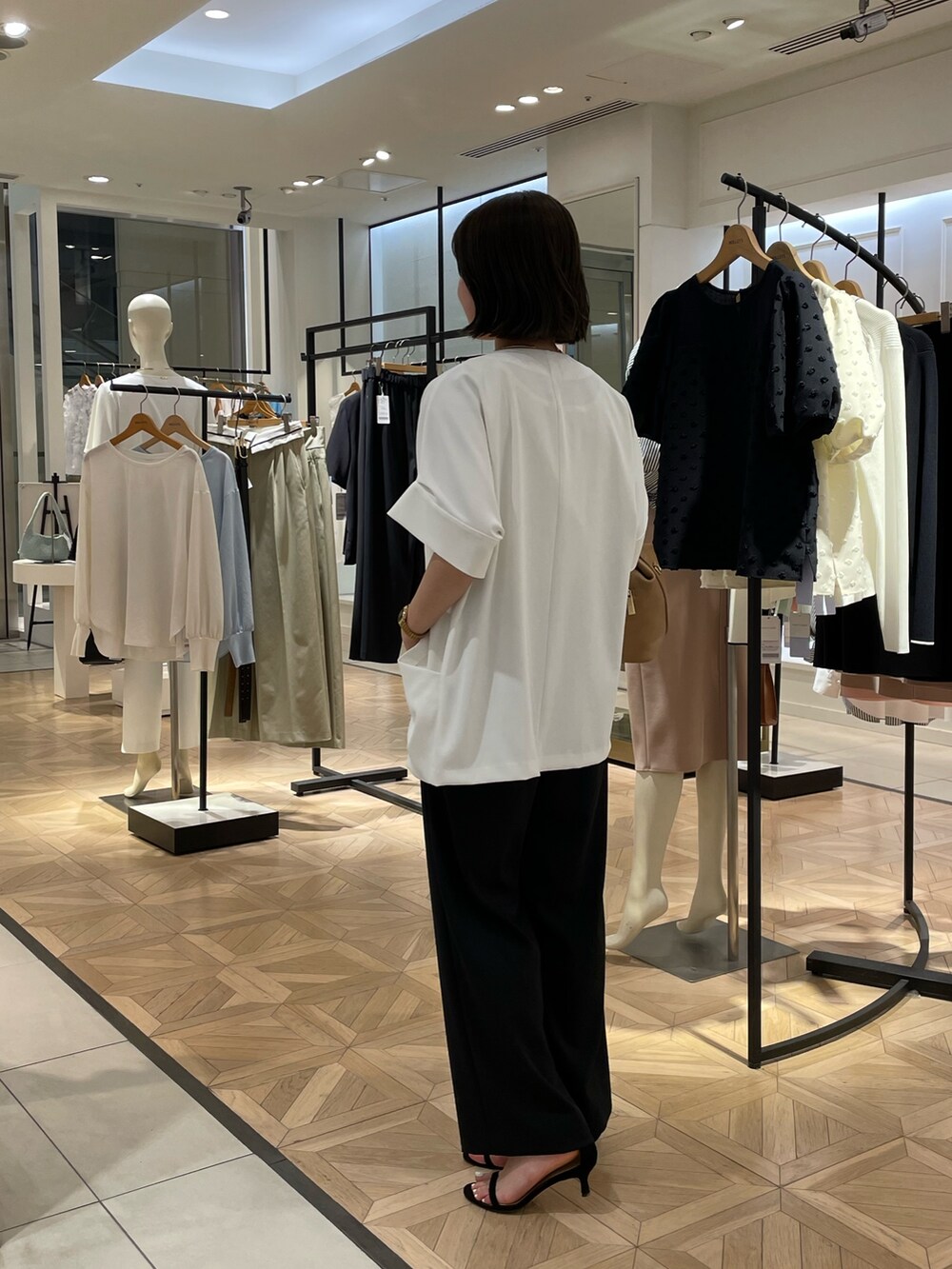 ブラック系のその他パンツ、ホワイト系のノーカラージャケット、ホワイト系のタンクトップを着用したレディースの春コーディネートの4枚目の写真