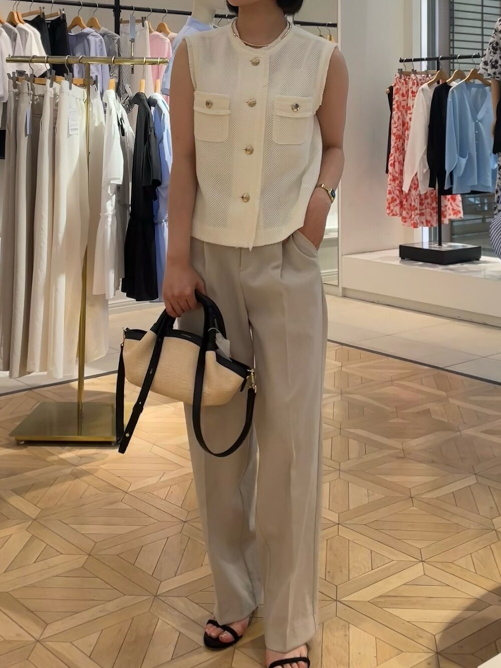 ホワイト系のベスト、ベージュ系のその他パンツを着用したレディースの夏コーディネートの3枚目の写真