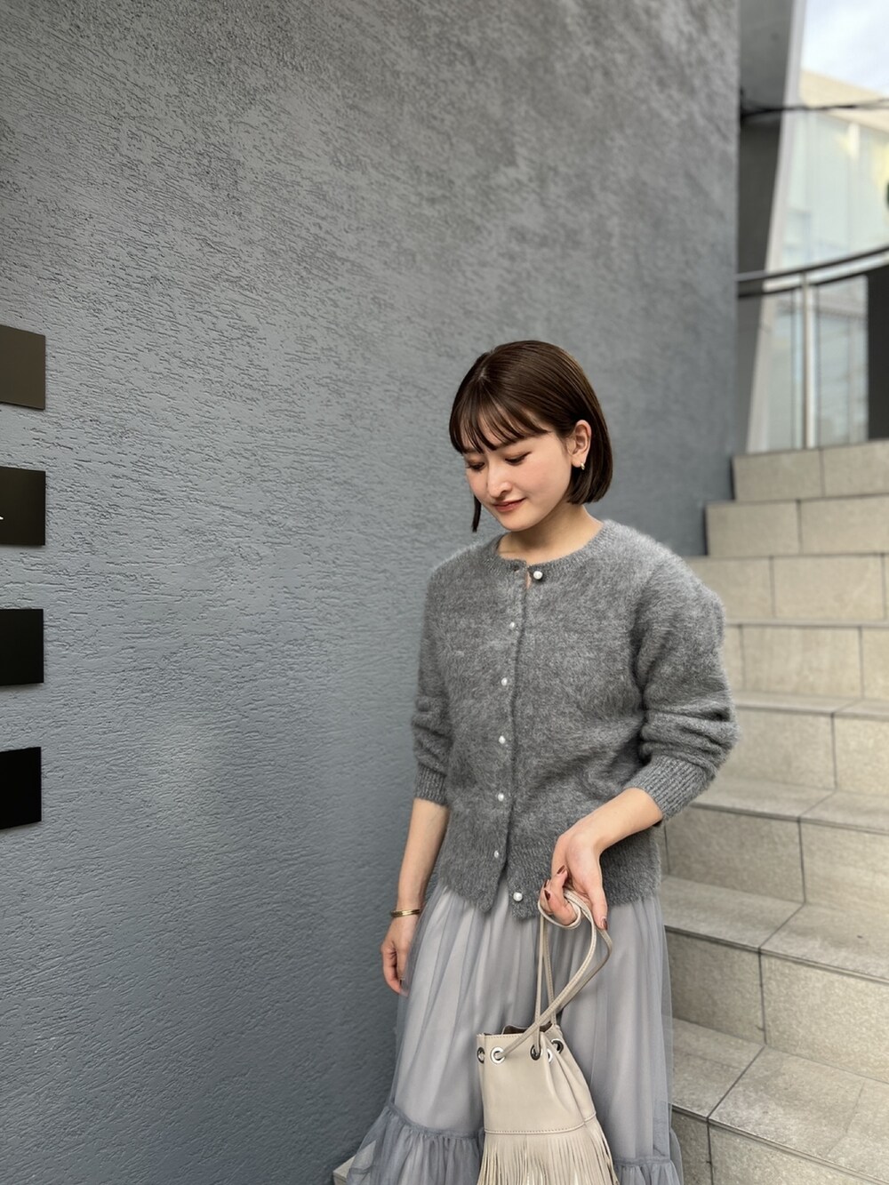 グレー系のカーディガン/ボレロ、グレー系のスカートを着用したレディースの冬コーディネートの5枚目の写真