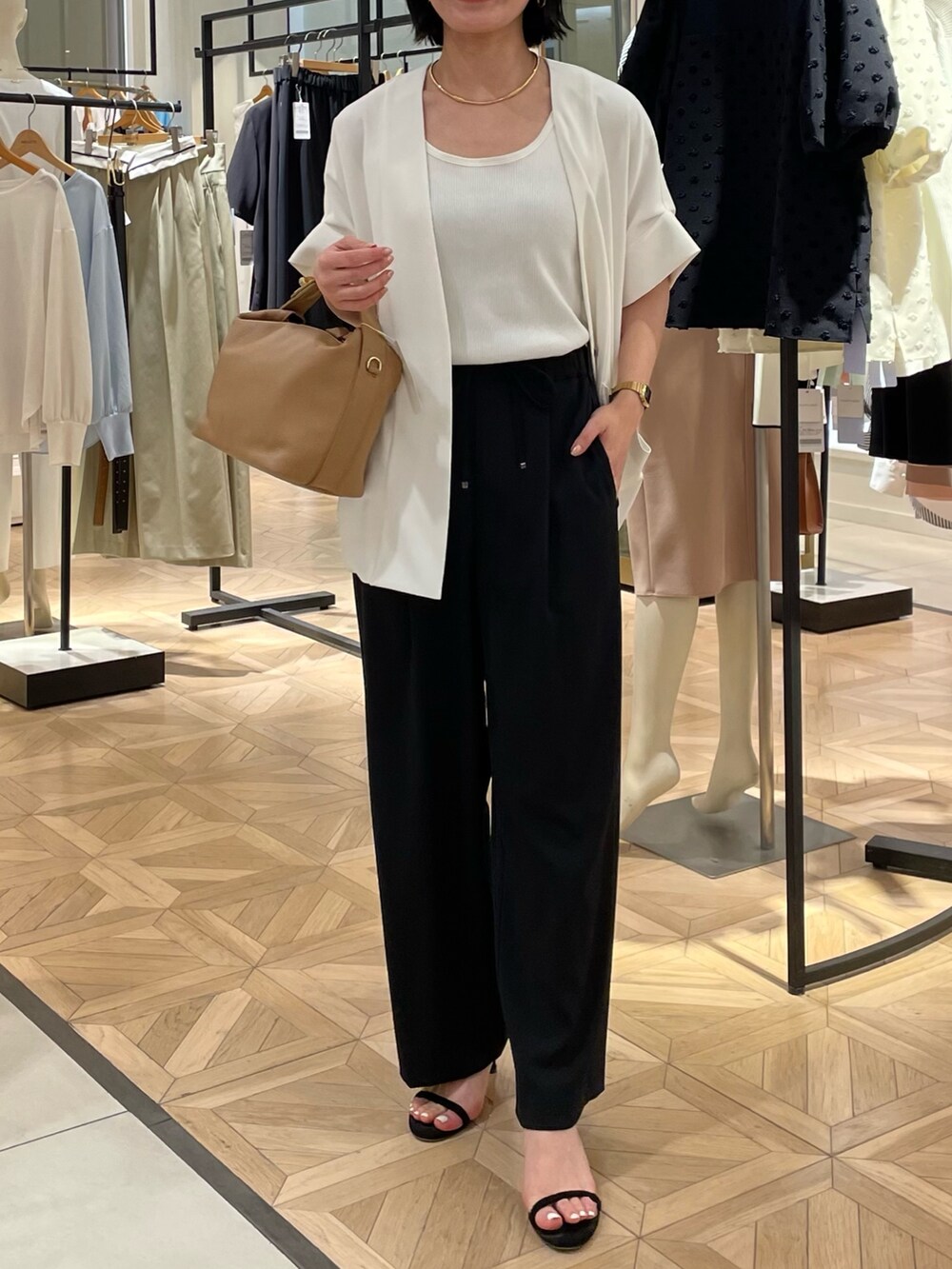 ブラック系のその他パンツ、ホワイト系のノーカラージャケット、ホワイト系のタンクトップを着用したレディースの春コーディネートの3枚目の写真