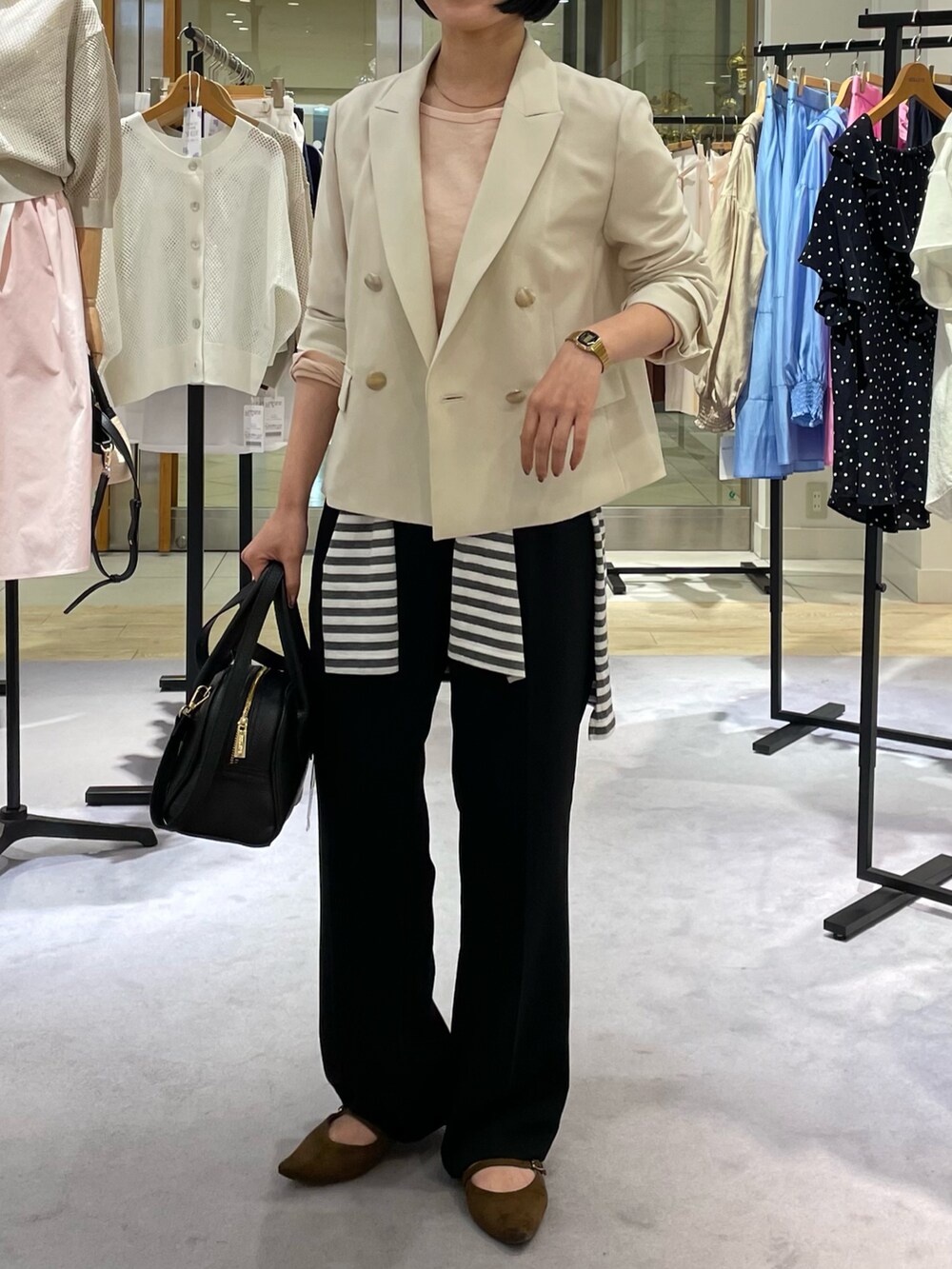 ベージュ系のテーラードジャケット、ピンク系のTシャツ/カットソー、ブラック系のその他パンツを着用したレディースの春コーディネートの2枚目の写真