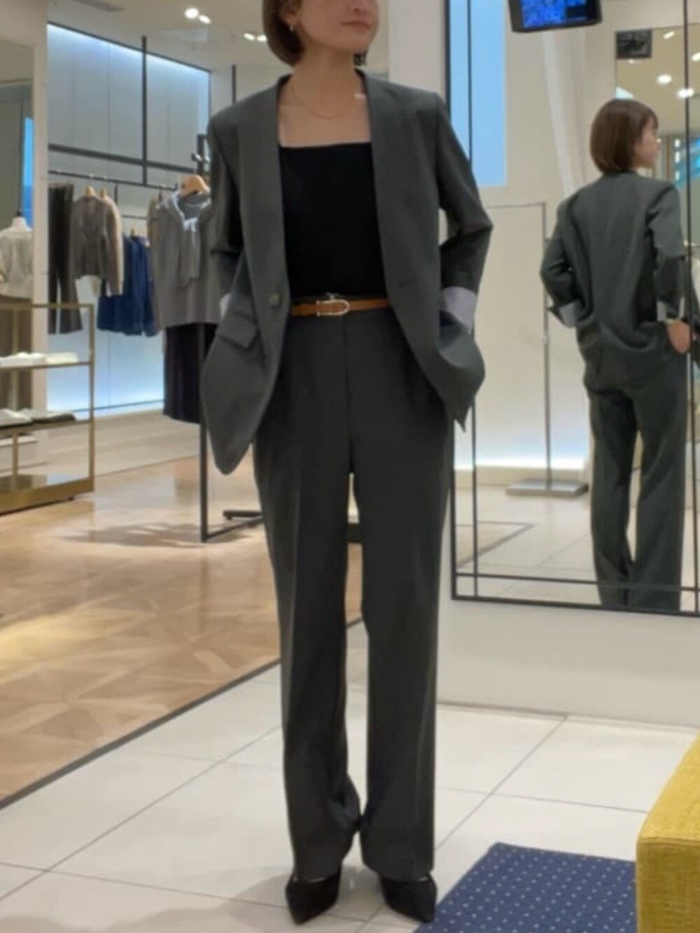 グレー系のノーカラージャケット、グレー系のその他パンツ、ブラック系のタンクトップを着用したレディースの秋コーディネートの5枚目の写真
