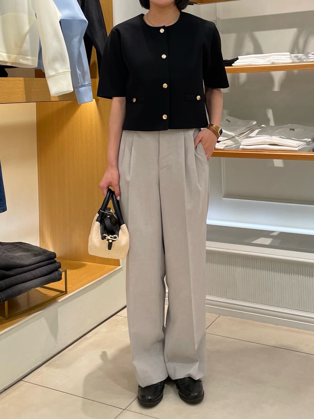 ブラック系のノーカラージャケット、グレー系のその他パンツを着用したレディースの春コーディネートの2枚目の写真