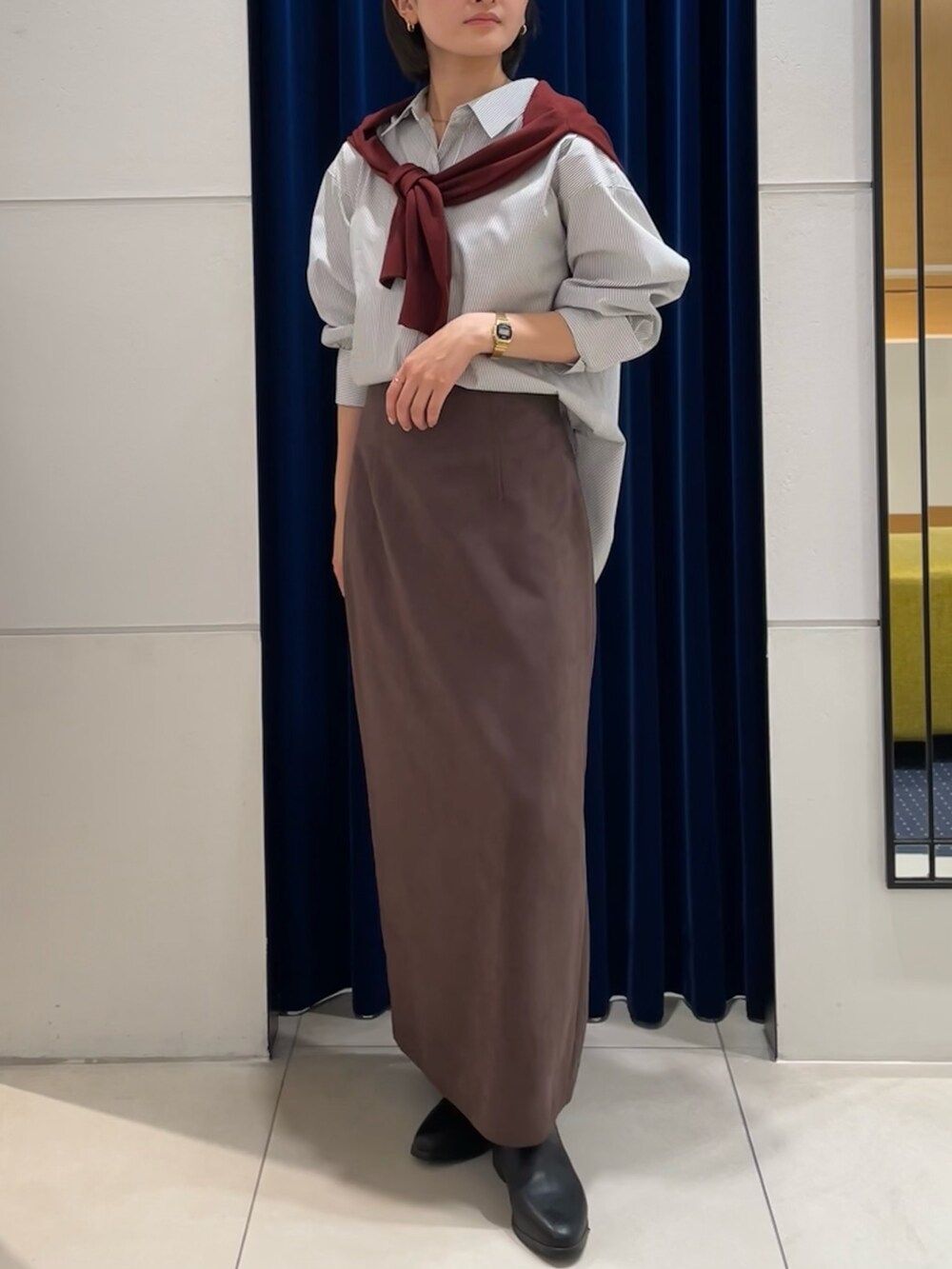 ホワイト系のシャツ/ブラウス、レッド系のカーディガン/ボレロ、ブラウン系のスカートを着用したレディースの秋コーディネートの3枚目の写真