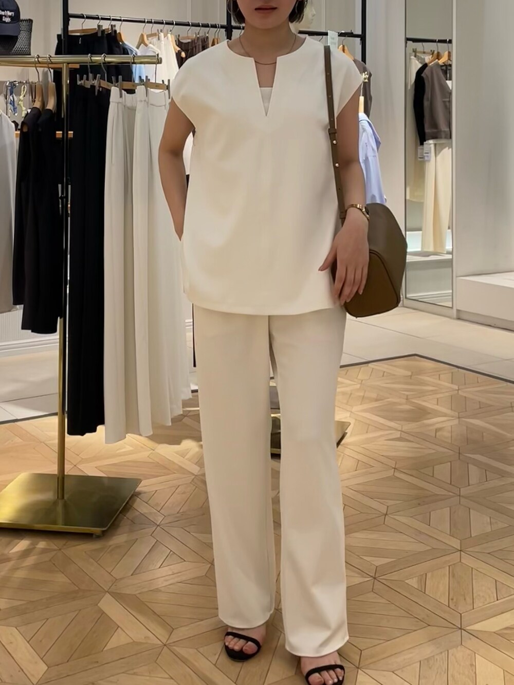 ホワイト系のTシャツ/カットソー、ホワイト系のその他パンツ、ブラウン系のショルダーバッグを着用したレディースの夏コーディネートの4枚目の写真