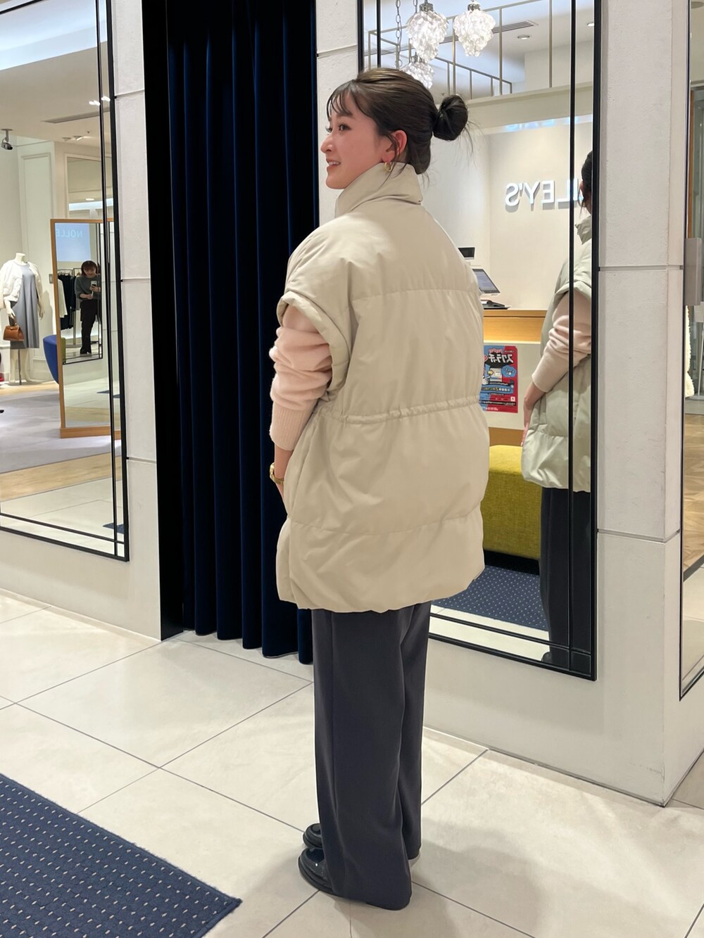 ベージュ系のダウンベスト、ピンク系のニット/セーター、グレー系のその他パンツを着用したレディースの冬コーディネートの3枚目の写真