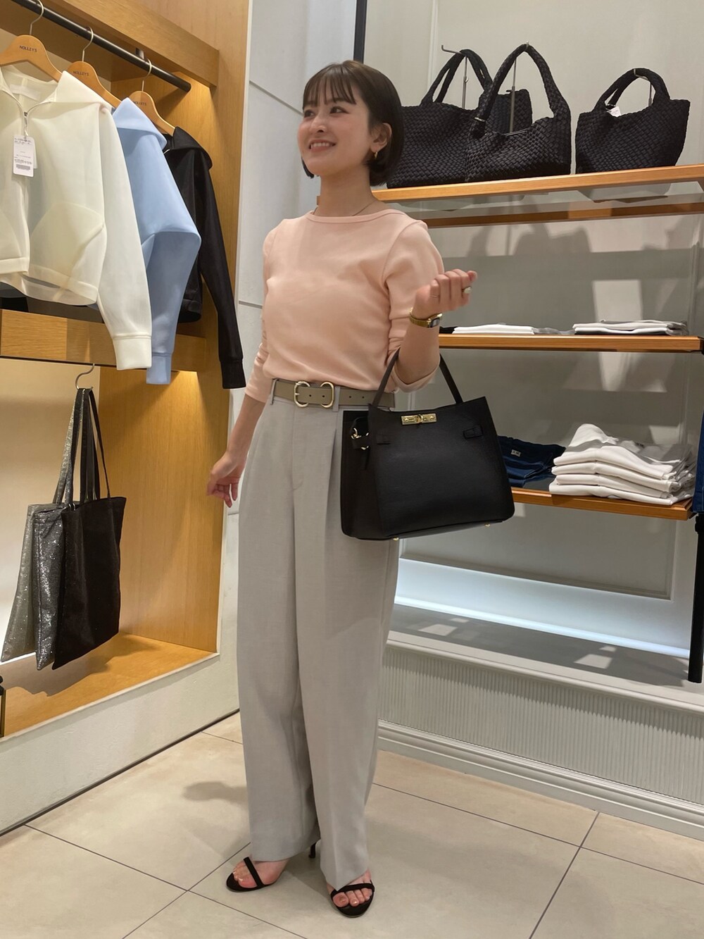 グレー系のその他パンツ、ピンク系のTシャツ/カットソー、ブラック系のショルダーバッグを着用したレディースの春コーディネートの2枚目の写真