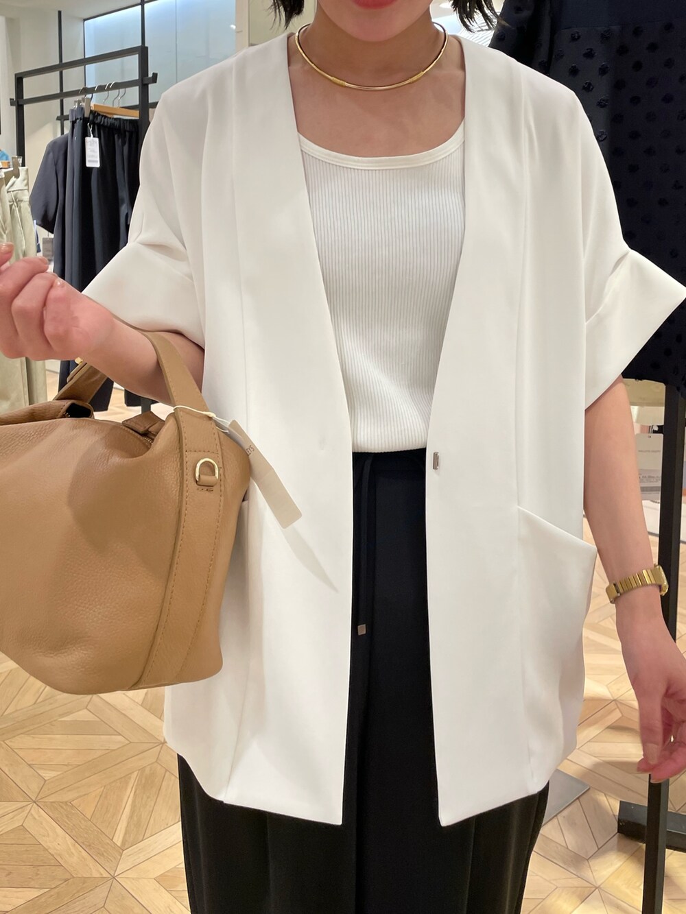 ブラック系のその他パンツ、ホワイト系のノーカラージャケット、ホワイト系のタンクトップを着用したレディースの春コーディネートの5枚目の写真