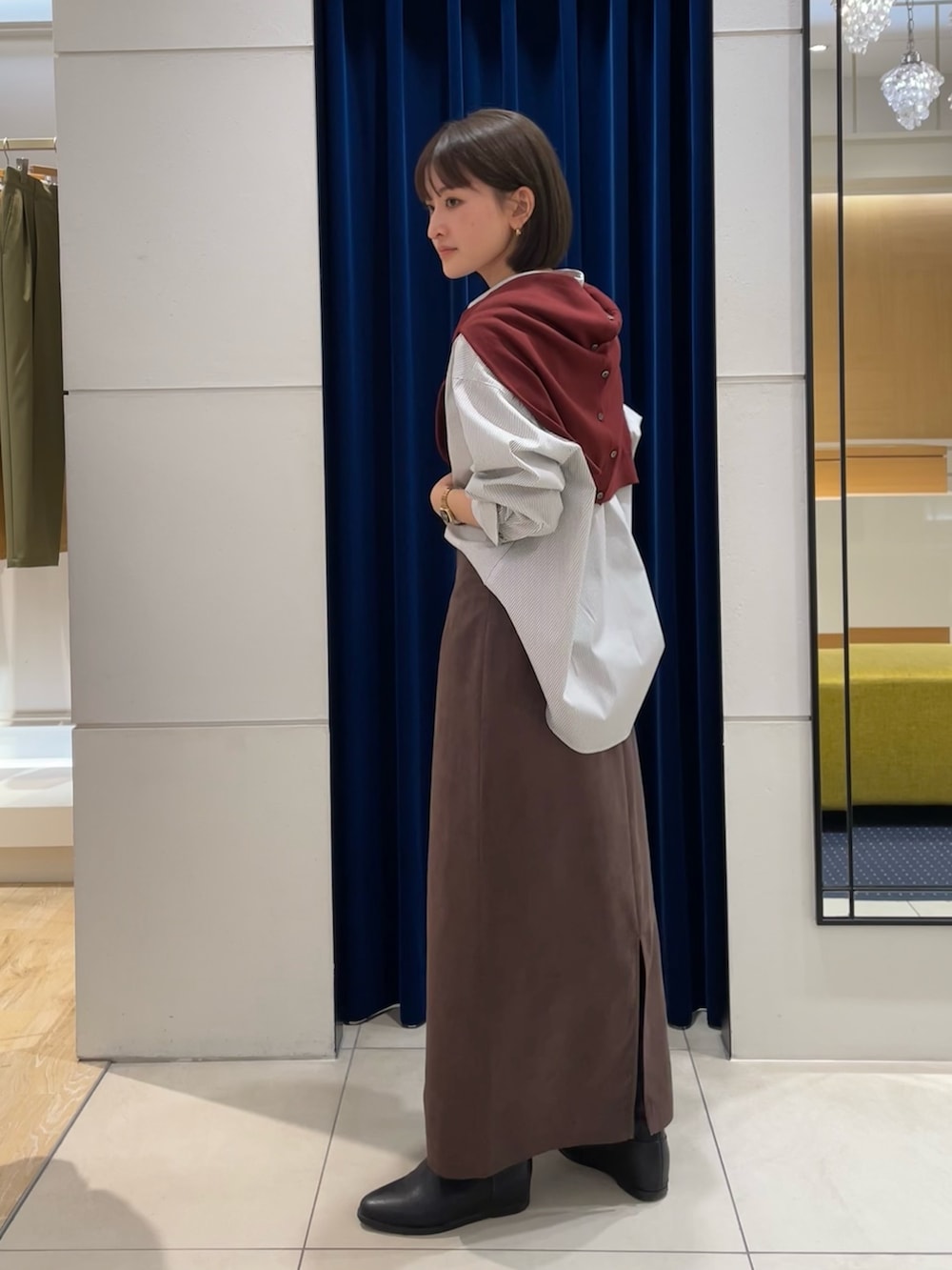 ホワイト系のシャツ/ブラウス、レッド系のカーディガン/ボレロ、ブラウン系のスカートを着用したレディースの秋コーディネートの4枚目の写真