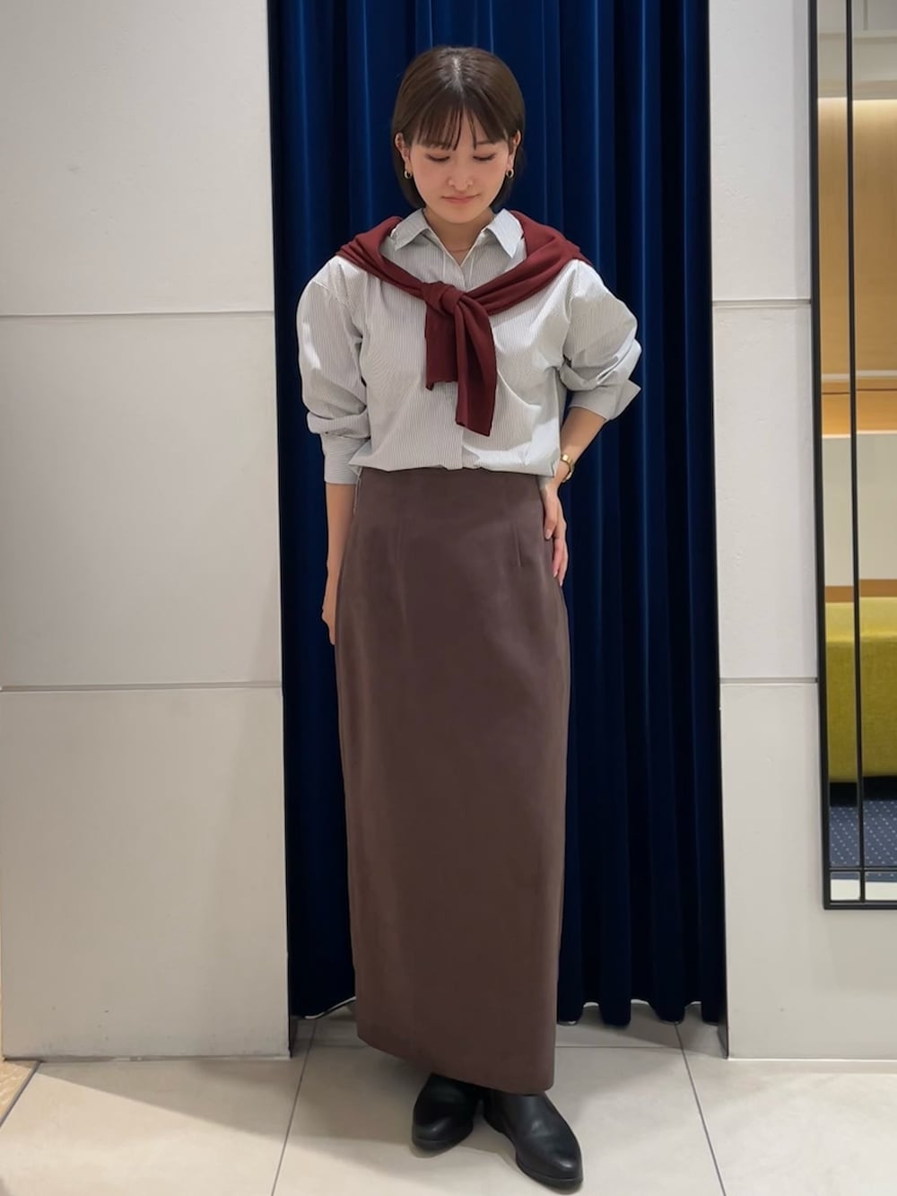 ホワイト系のシャツ/ブラウス、レッド系のカーディガン/ボレロ、ブラウン系のスカートを着用したレディースの秋コーディネートの2枚目の写真