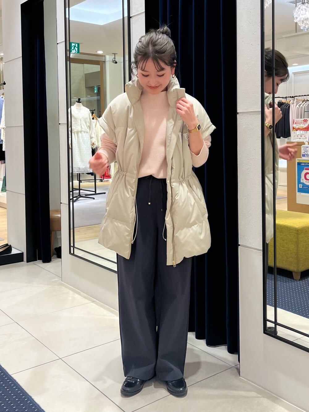 ベージュ系のダウンベスト、ピンク系のニット/セーター、グレー系のその他パンツを着用したレディースの冬コーディネートの2枚目の写真