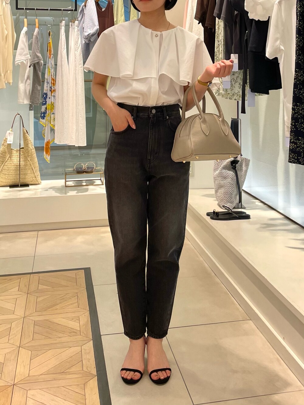 ホワイト系のシャツ/ブラウス、ブラック系のデニムパンツを着用したレディースの春コーディネートの2枚目の写真