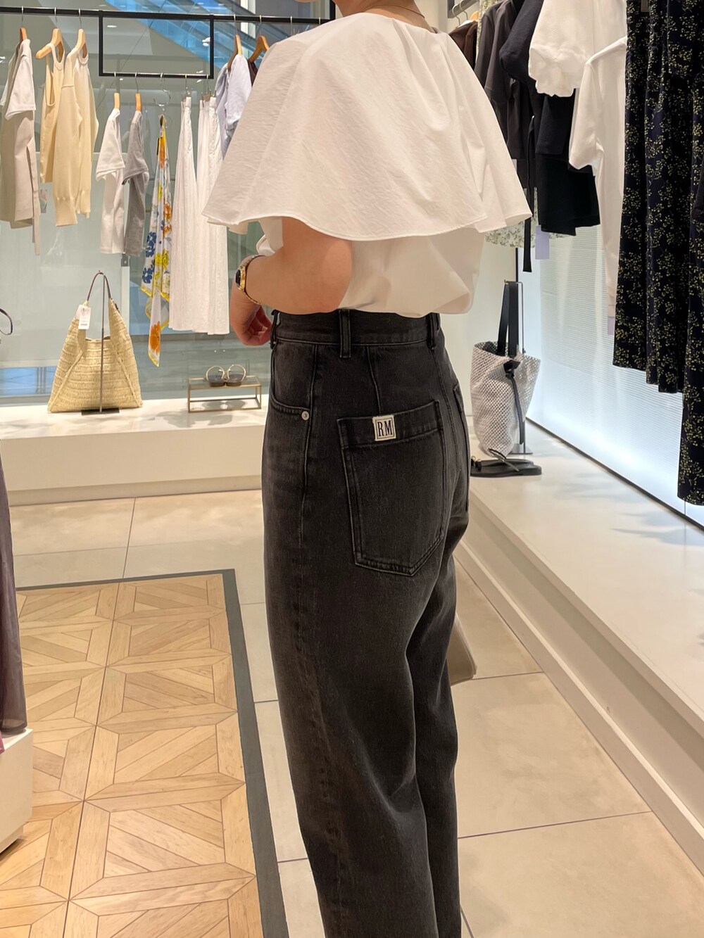 ホワイト系のシャツ/ブラウス、ブラック系のデニムパンツを着用したレディースの春コーディネートの3枚目の写真