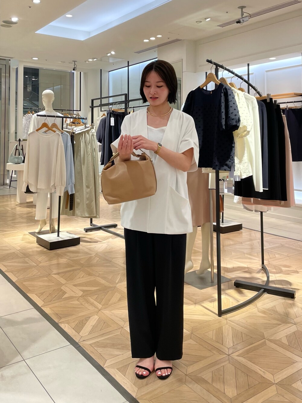 ブラック系のその他パンツ、ホワイト系のノーカラージャケット、ホワイト系のタンクトップを着用したレディースの春コーディネートの2枚目の写真