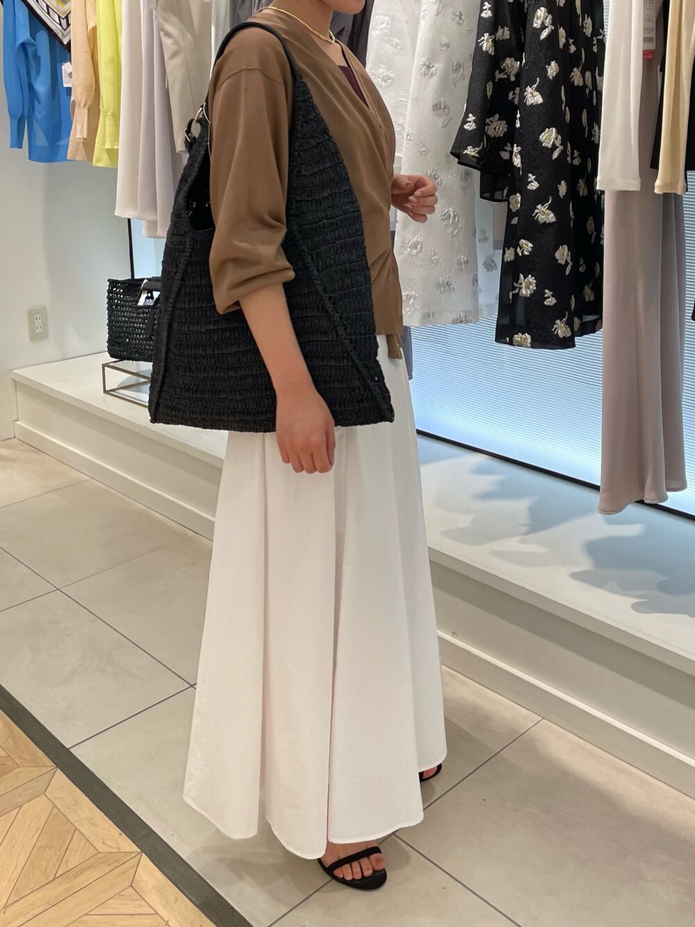 ブラウン系のカーディガン/ボレロ、ホワイト系のスカートを着用したレディースの春コーディネートの2枚目の写真