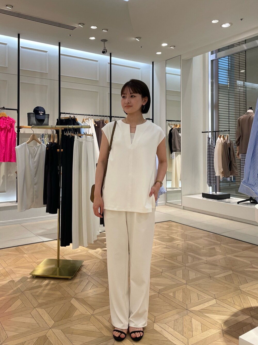 ホワイト系のTシャツ/カットソー、ホワイト系のその他パンツ、ブラウン系のショルダーバッグを着用したレディースの夏コーディネートの3枚目の写真