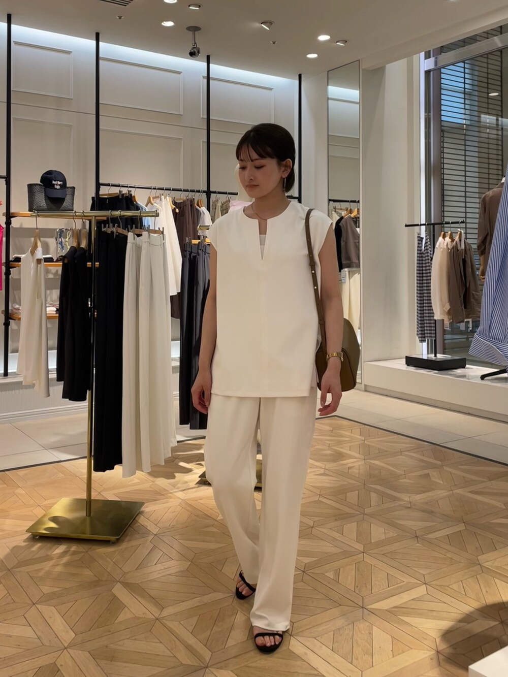 ホワイト系のTシャツ/カットソー、ホワイト系のその他パンツ、ブラウン系のショルダーバッグを着用したレディースの夏コーディネートの2枚目の写真