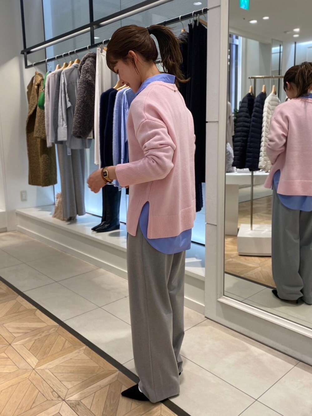 ピンク系のニット/セーター、ブルー系のシャツ/ブラウス、グレー系のその他パンツを着用したレディースの秋コーディネートの2枚目の写真