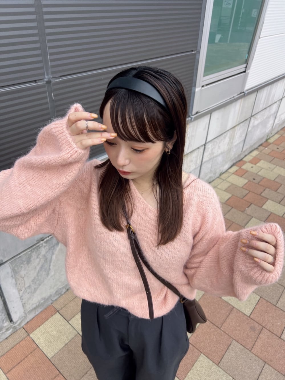 ピンク系のニット/セーターを着用したレディースの秋コーディネートの2枚目の写真
