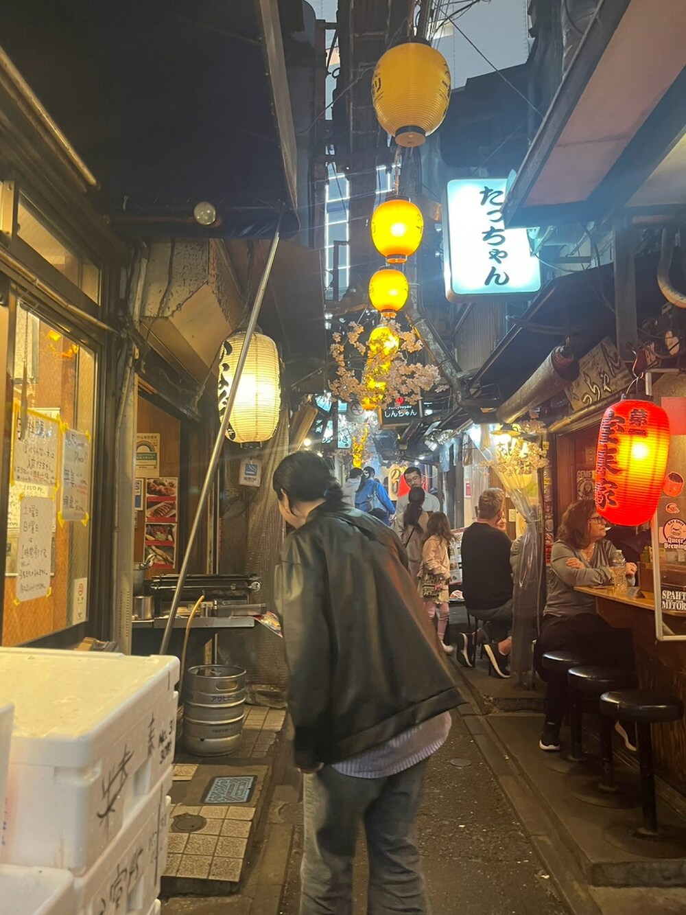 ブラック系のライダースジャケット、ブルー系のシャツ/ブラウス、グレー系のデニムパンツを着用したレディースの春コーディネートの2枚目の写真