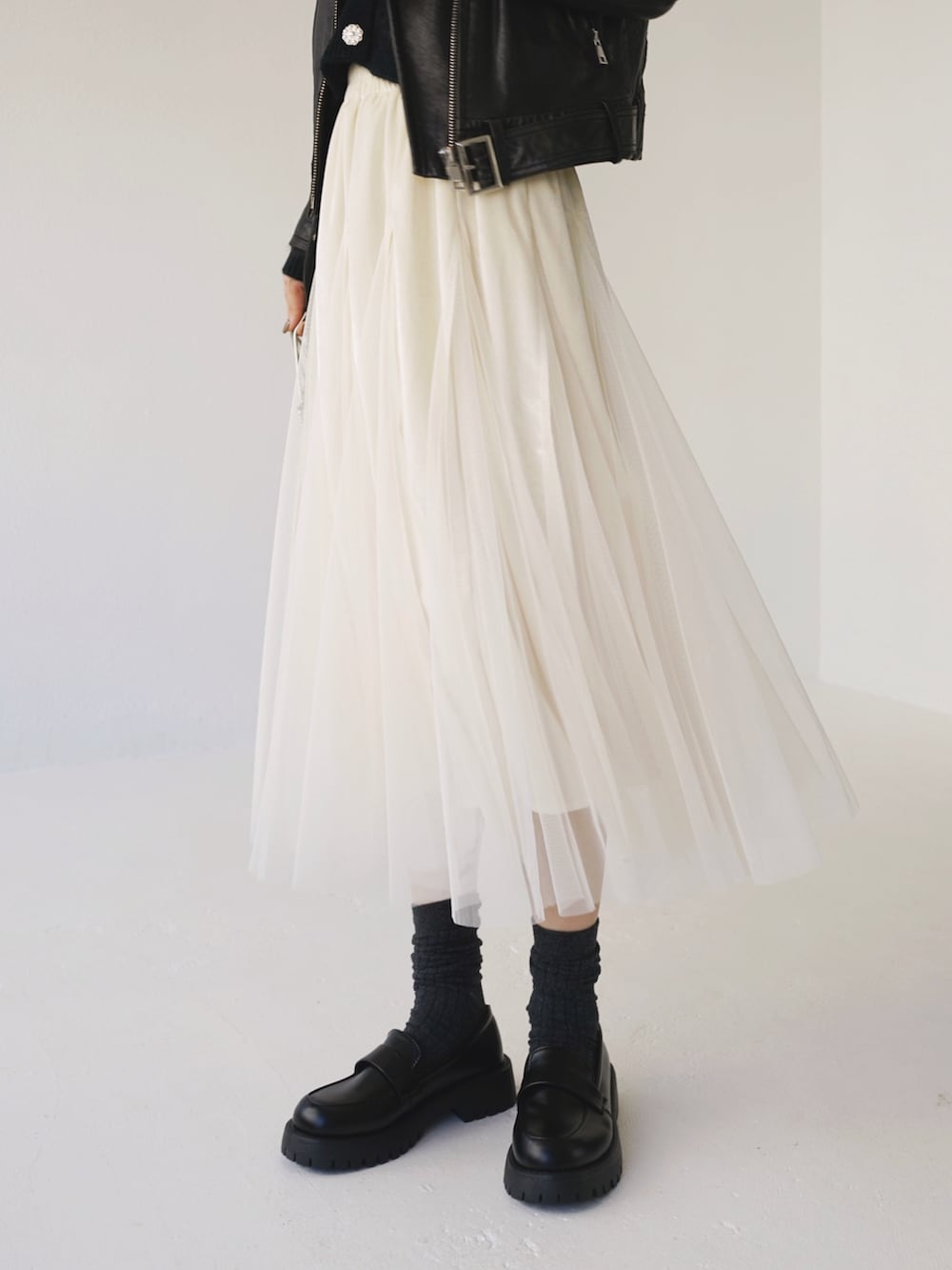 ブラック系のカーディガン/ボレロ、ベージュ系のスカートを着用したレディースの冬コーディネートの5枚目の写真