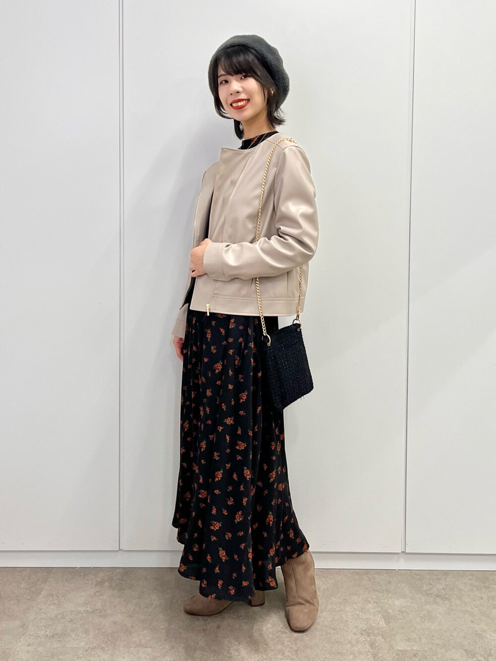 グレー系のブーツ、ブラック系のワンピース、ベージュ系のライダースジャケットを着用したレディースの秋コーディネートの3枚目の写真