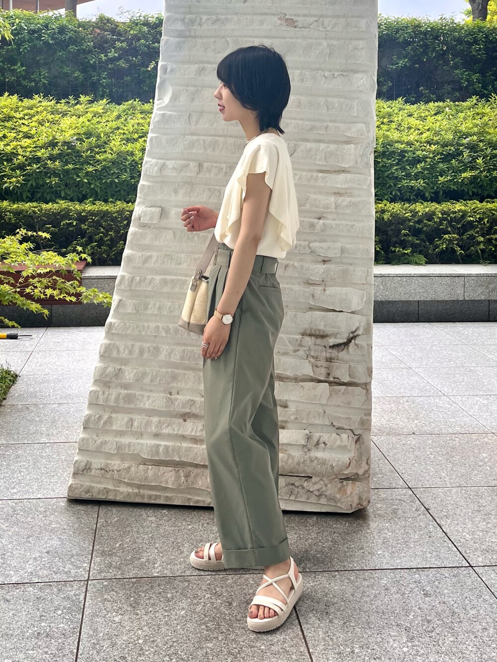 グレー系のショルダーバッグ、ホワイト系のサンダル、ホワイト系のニット/セーターを着用したレディースの夏コーディネートの5枚目の写真