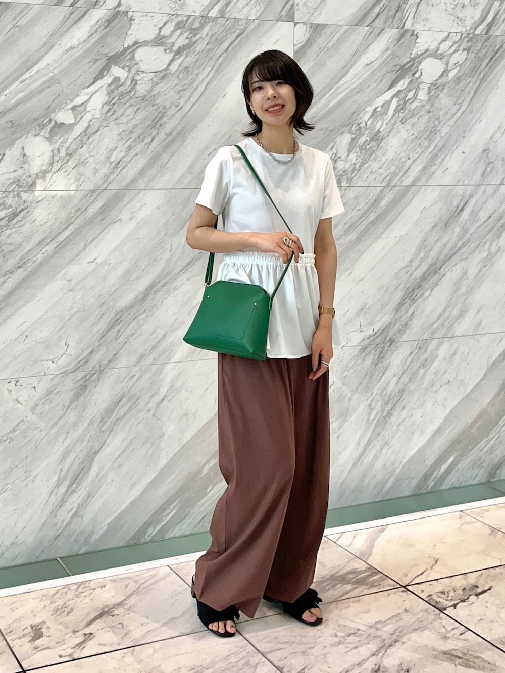 ブラック系のサンダル、ブラウン系のその他パンツ、グリーン系のショルダーバッグを着用したレディースの夏コーディネートの4枚目の写真