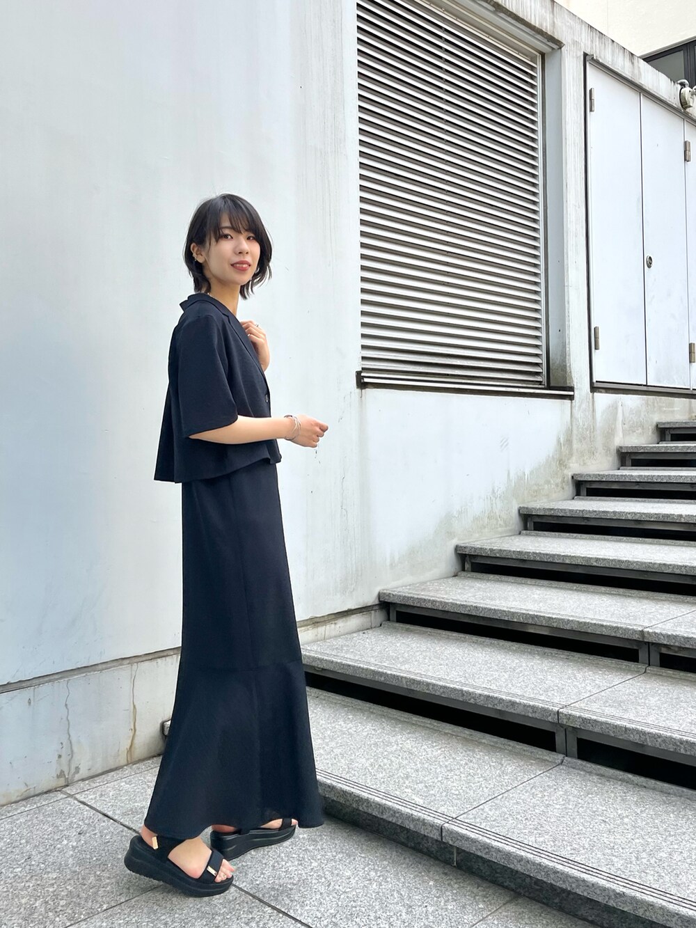 ブラック系のアンサンブル、ベージュ系のタンクトップ、ブラック系のサンダルを着用したレディースの夏コーディネートの5枚目の写真